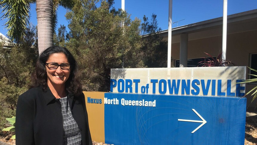 woman in front of townsville port sign