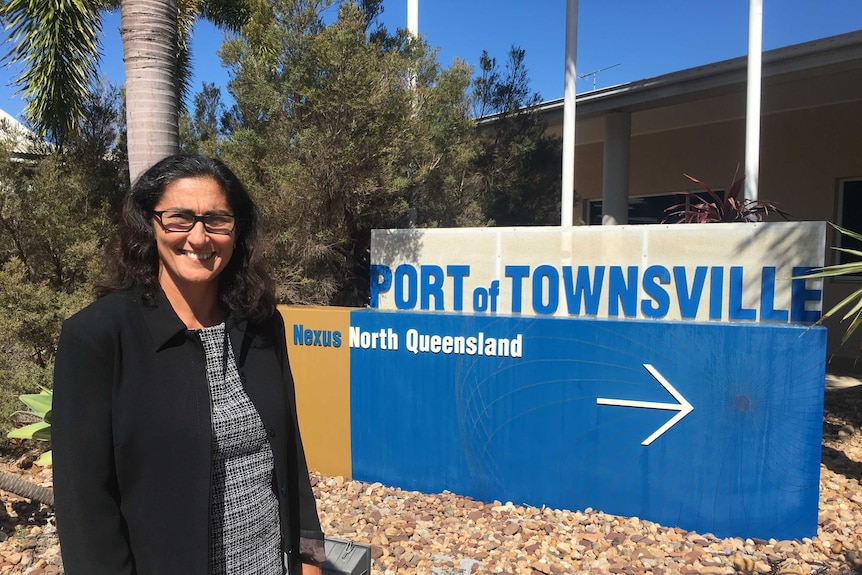 woman in front of townsville port sign
