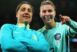 Steph Catley and Sam Kerr look into the crowd together and smile