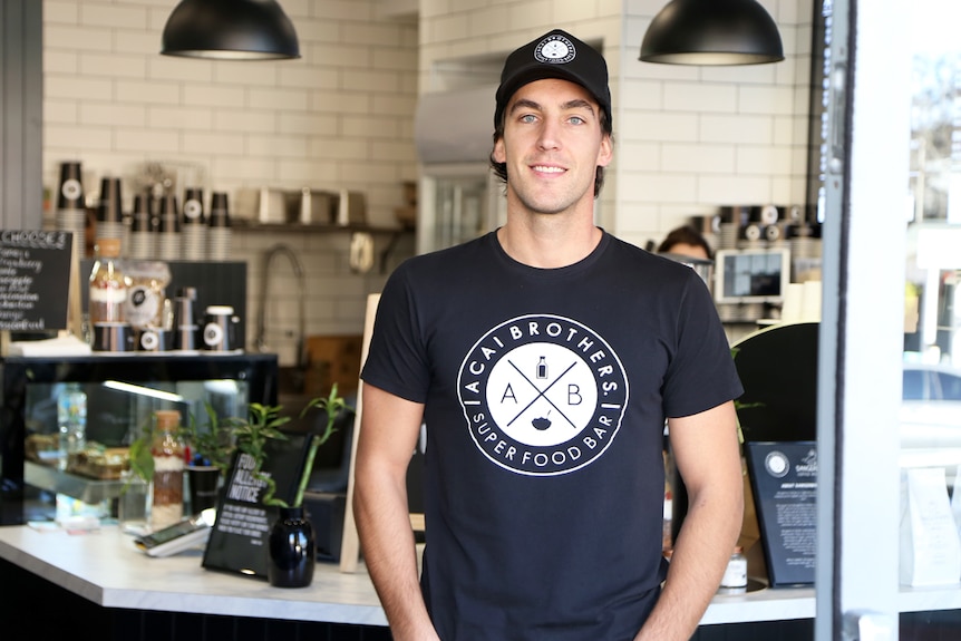 Scott Murray stands in the doorway of his cafe.