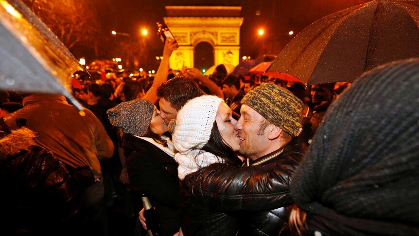 Two revellers kiss during New Year celebrations in Paris.