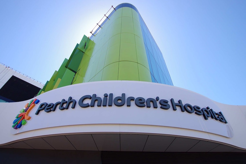 A shot from the ground of a Perth Children's Hospital sign and green building.