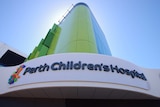 A shot from the ground of a Perth Children's Hospital sign and green building.