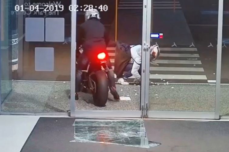 A still image taken from CCTV footage showing two burglars fleeing a shopping centre with one on a bike.