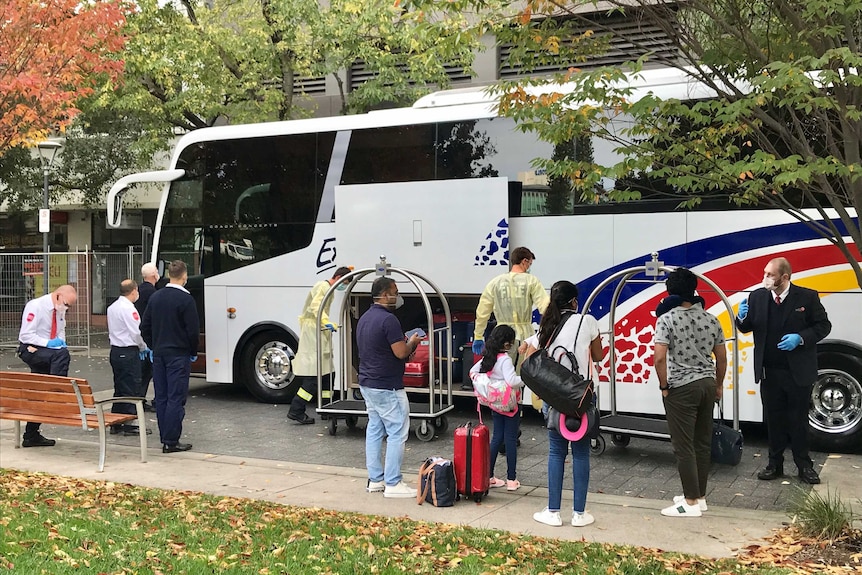 Travellers arriving at the Pullman Hotel, security staff and emergency services workers standing nearby.