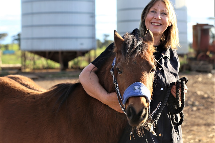 Photo of a woman and a horse.