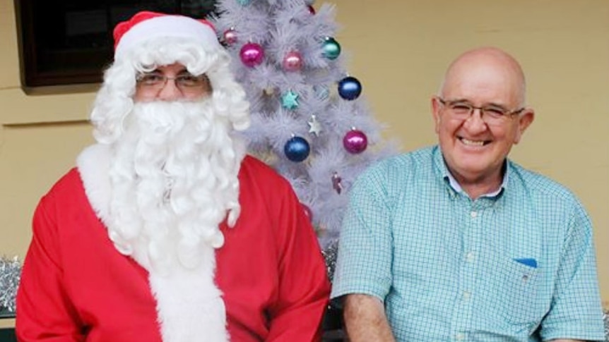 A man in front of a Christmas tree