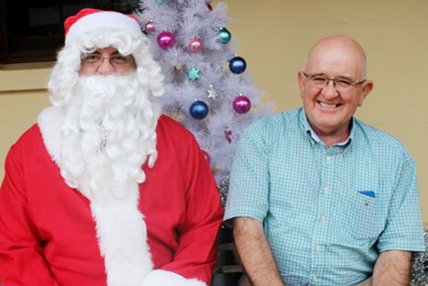 A man in front of a Christmas tree