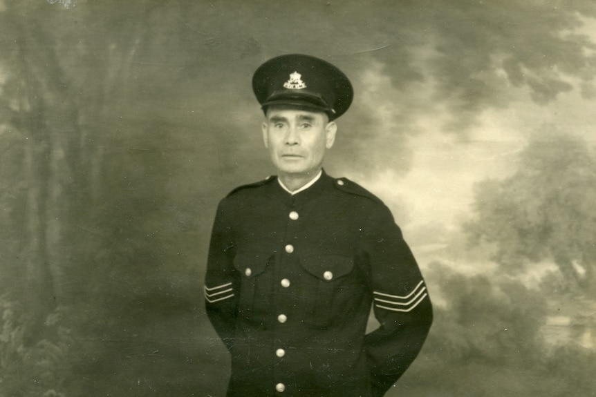 A black and white image of Tracker Riley standing in his sergeant's uniform