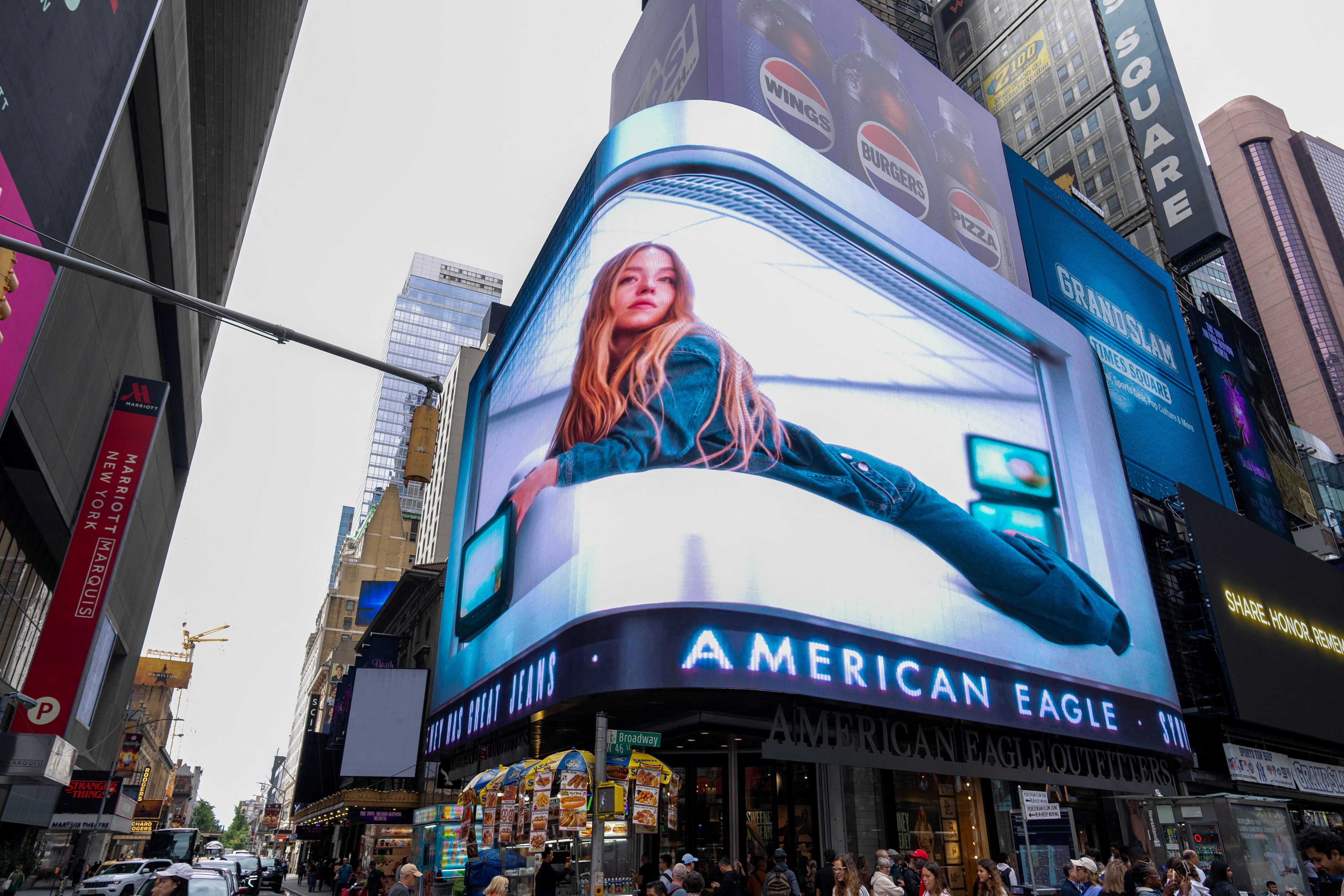 A blonde woman wearing denim pictured laying down in a billboard advertisement