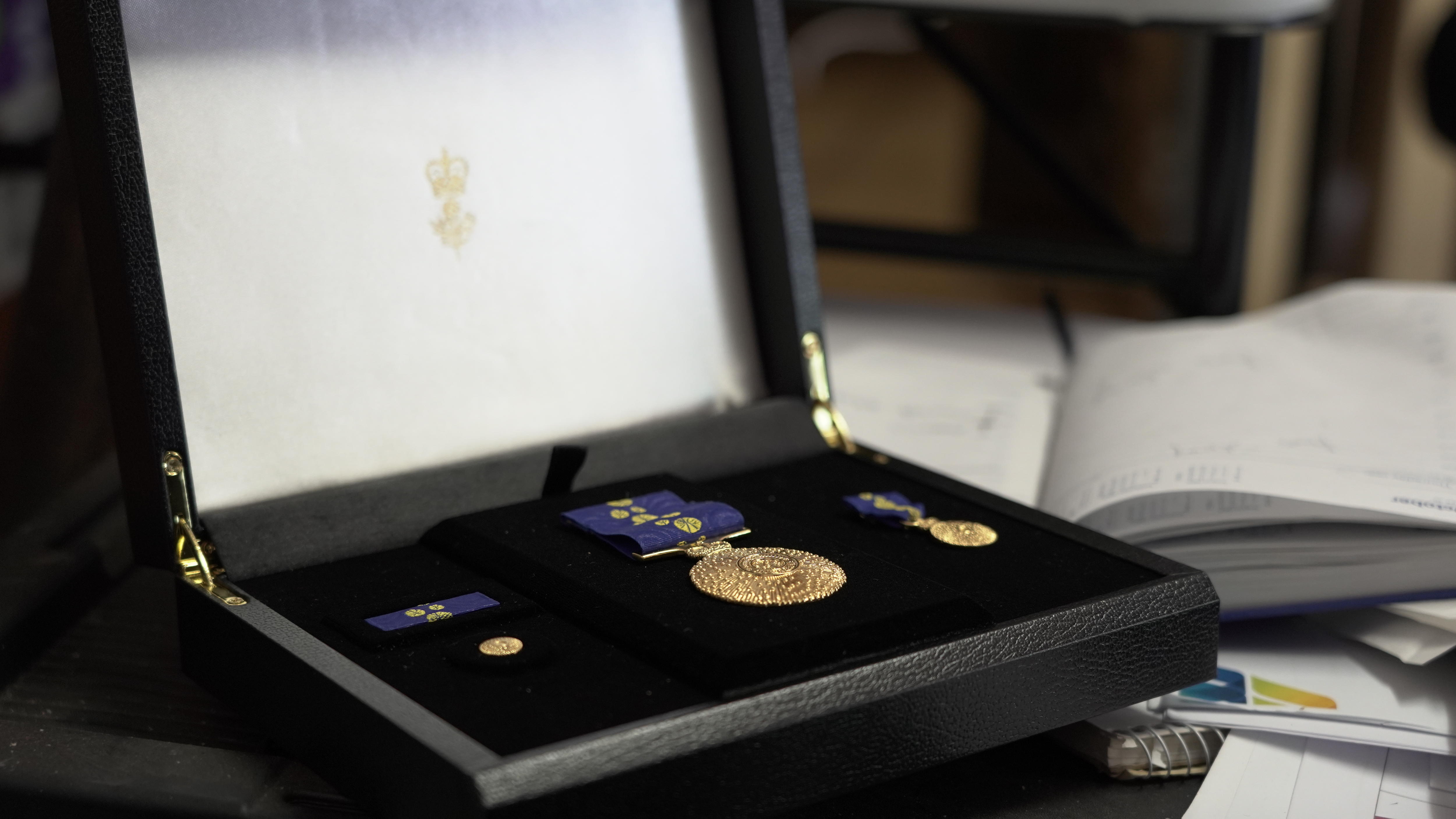 A gold Medal of the Order of Australia sitting in a box.