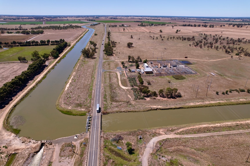 Aerial shot of an open water channel with a road running across it.