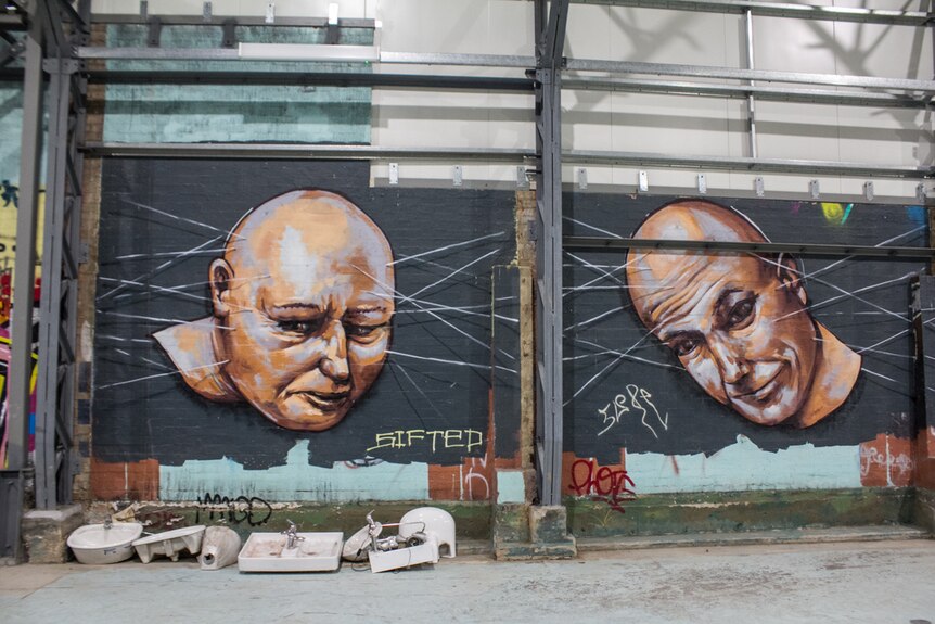Street art of two men's heads on wall.