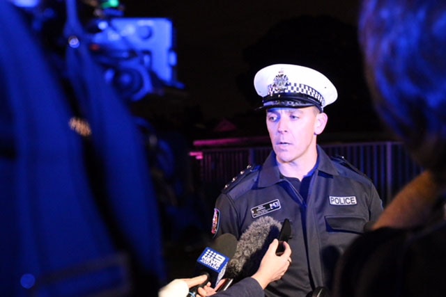 Inspector Dean Snashall speaks to the media on the street after a house fire.
