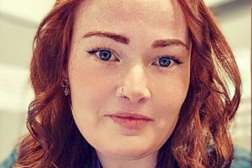 Rachel Butland, a woman with red hair and a nose piercing, looks into the camera. 
