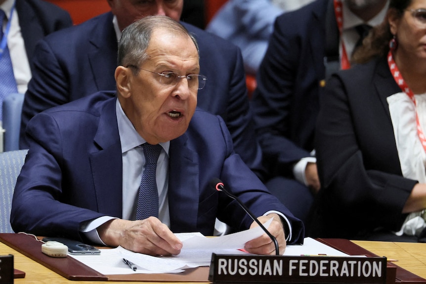 Sergei Lavrov sits behind a sign that says Russian Federation.
