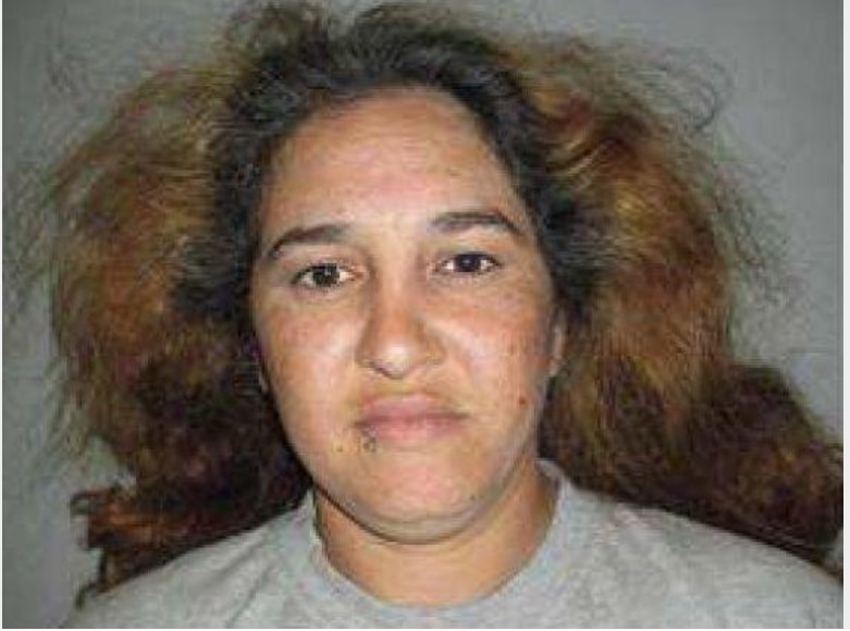 a woman looks at the camera against a plain background