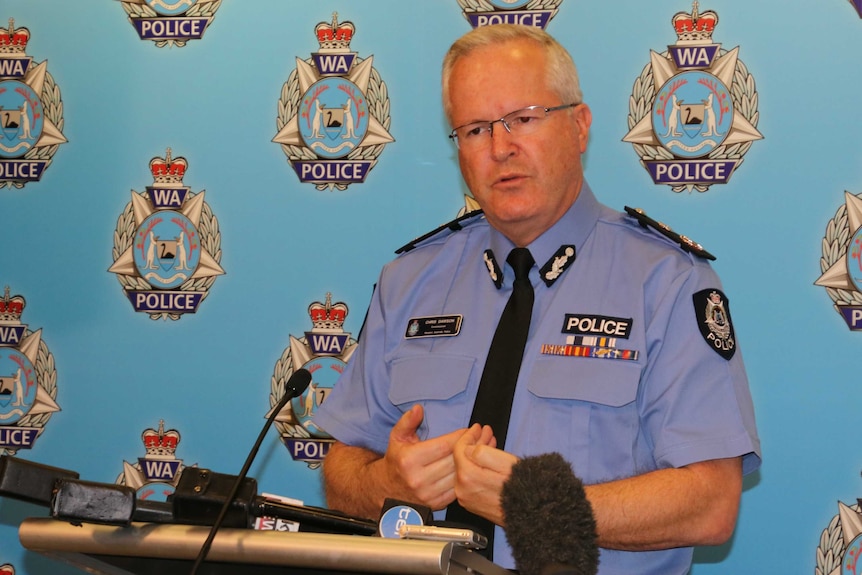 WA Police Commissioner Chris Dawson stands at a lectern against a backdrop of police insignia.