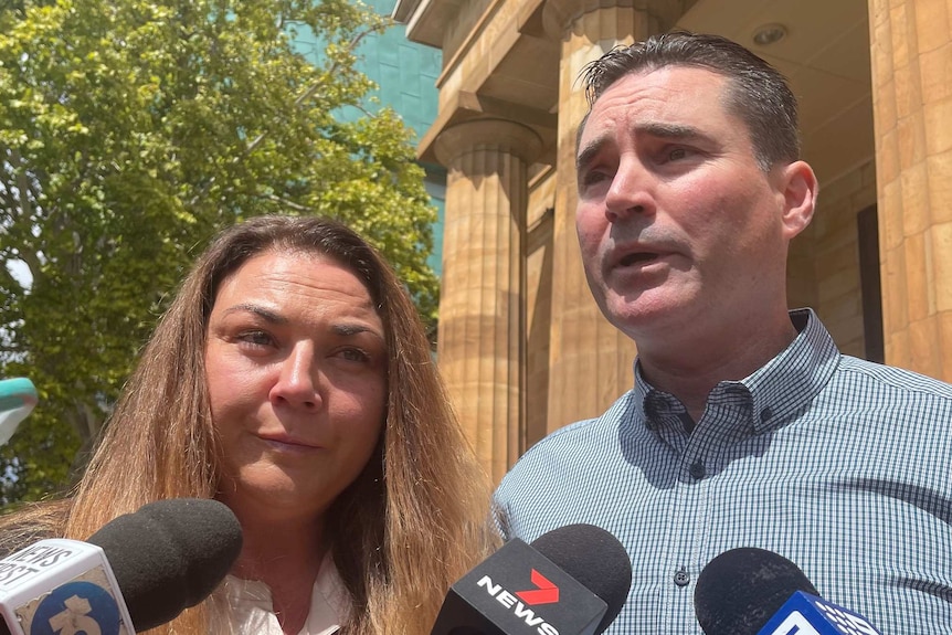 A woman and a man outside a court building.