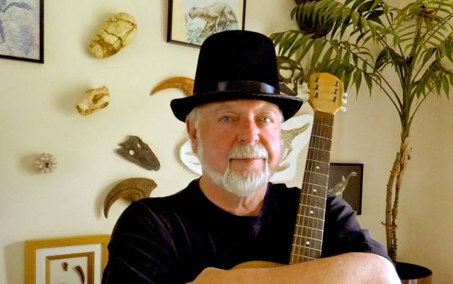 A man wearing a hat standing in front of fossils