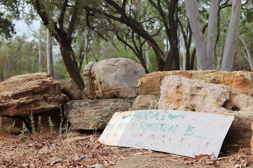 A photo of a sign leaning against some rocks that says Springvale Homestead is closed.