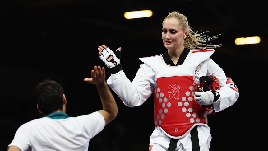 Australia's Carmen Marton celebrates with her coach after winning her first taekwondo bout.