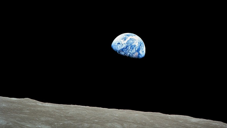 The earth rises above the horizon of the moon.
