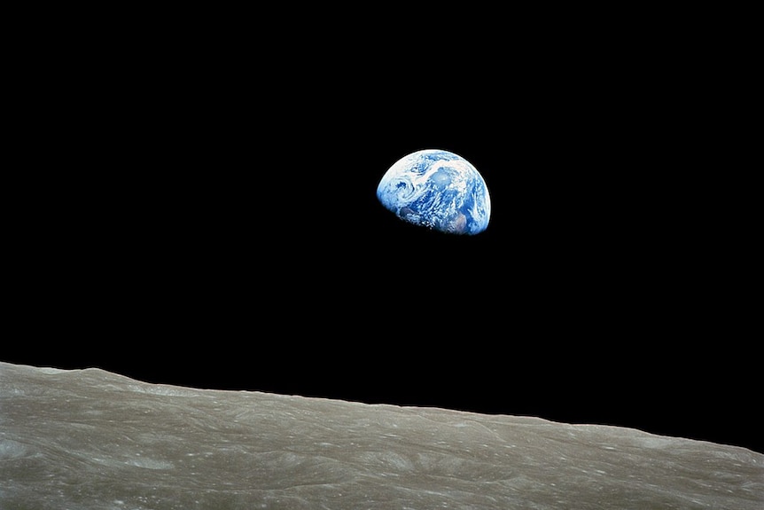 The earth rises above the horizon of the moon.