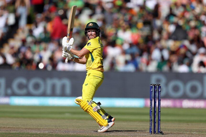 Australia batter Beth Mooney looks over her shoulder after a scoop shot in the women's T20 World Cup final.