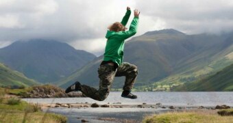 Teenager jumping over a creek.