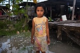 Teuga Patolo stands in king-tide waters that surround her neighbour's house at Funafui in Tuvalu.