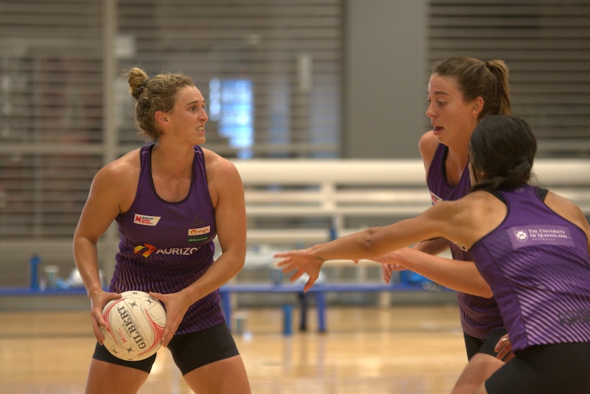 Netballers in purple training. 