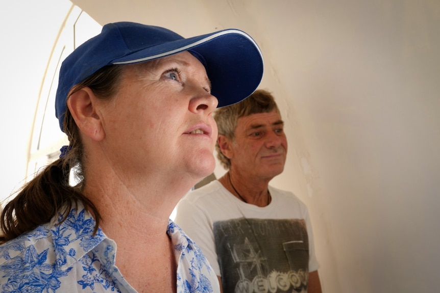 close up of couple inside house, woman looking up plaintively