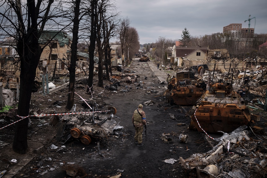 A man walks through destruction in Bucha. 