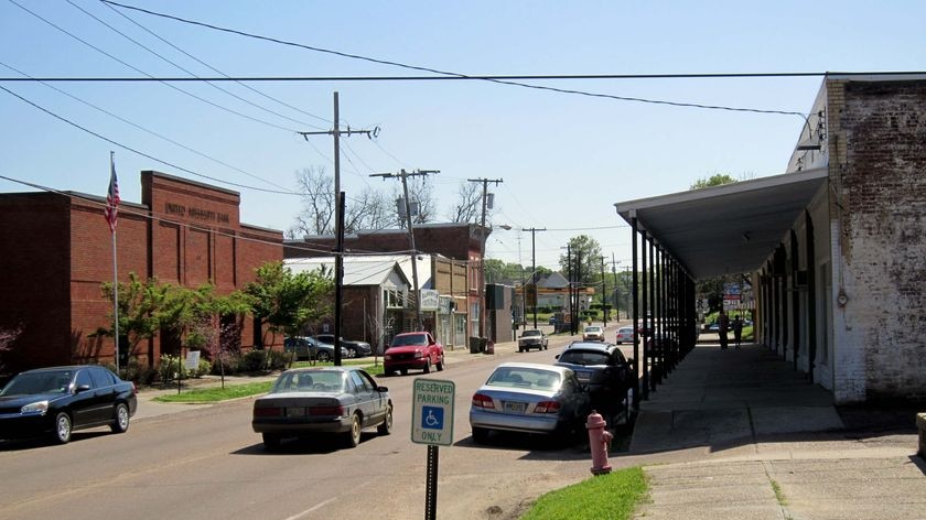 A car drives down the main street of Fayette, Mississippi
