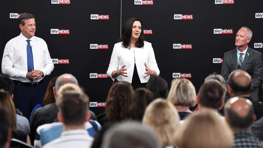 Annastacia Palaszczuk speaking, watched by Tim Nicholls and Steve Dickson