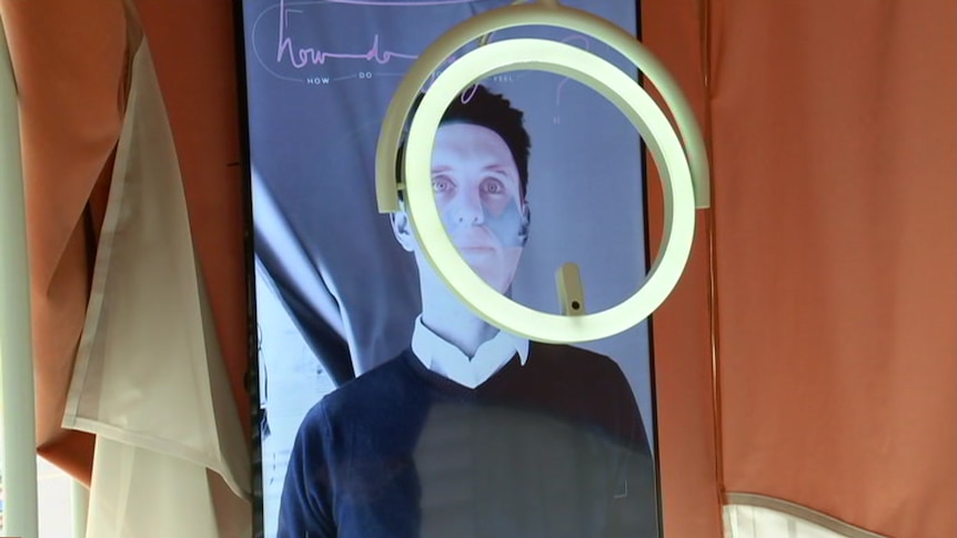 James Hancock at the biometric mirror, which is analysing his face.