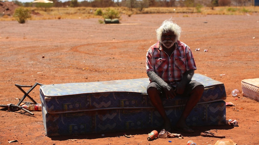 An Aboriginal elder sitting on his mattress next to the Parnpajinya community.