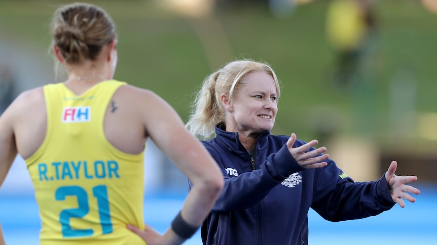 The Hockeyroos coach speaks to her players during a match in 2021.