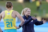 The Hockeyroos coach speaks to her players during a match in 2021.