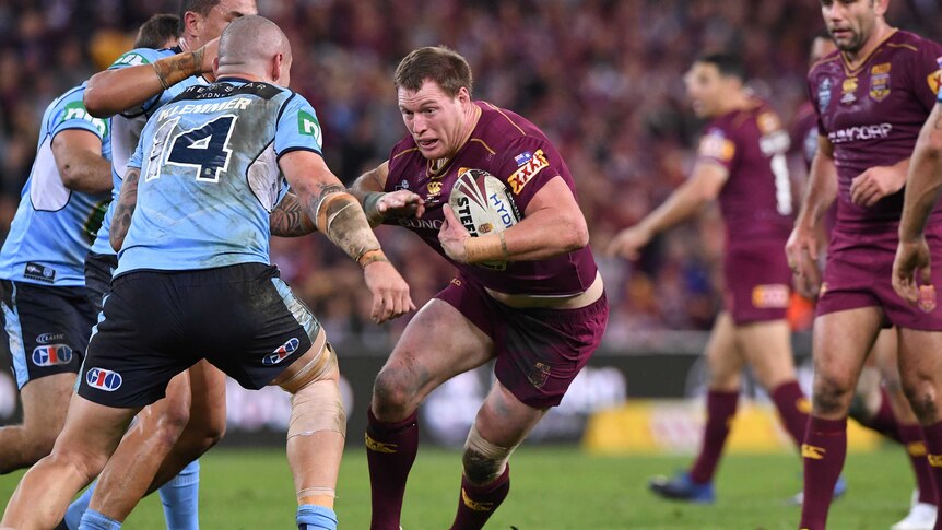 A Queensland forward runs with the ball at the NSW defence in State Of Origin