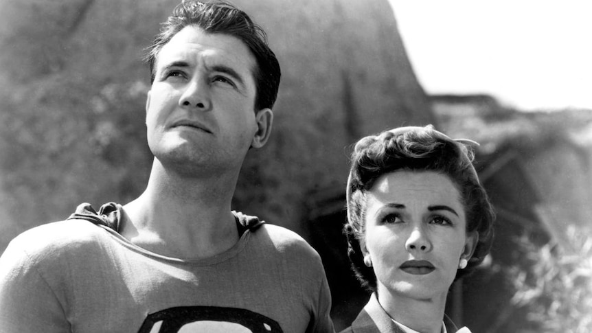 George Reeves as Superman/Clark Kent and Phyliss Cates as Loise Lane looking determined into the sky in a still from 1952