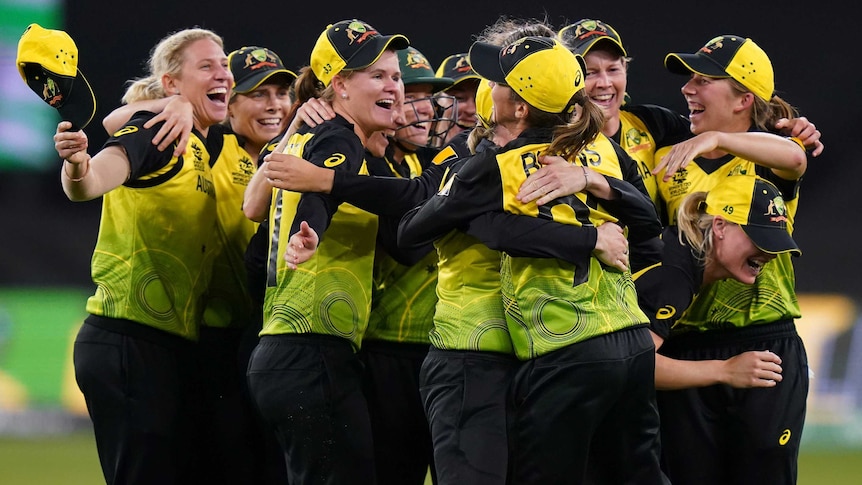 Australia's women's cricket team throw their arms around each other after the T20 World Cup final