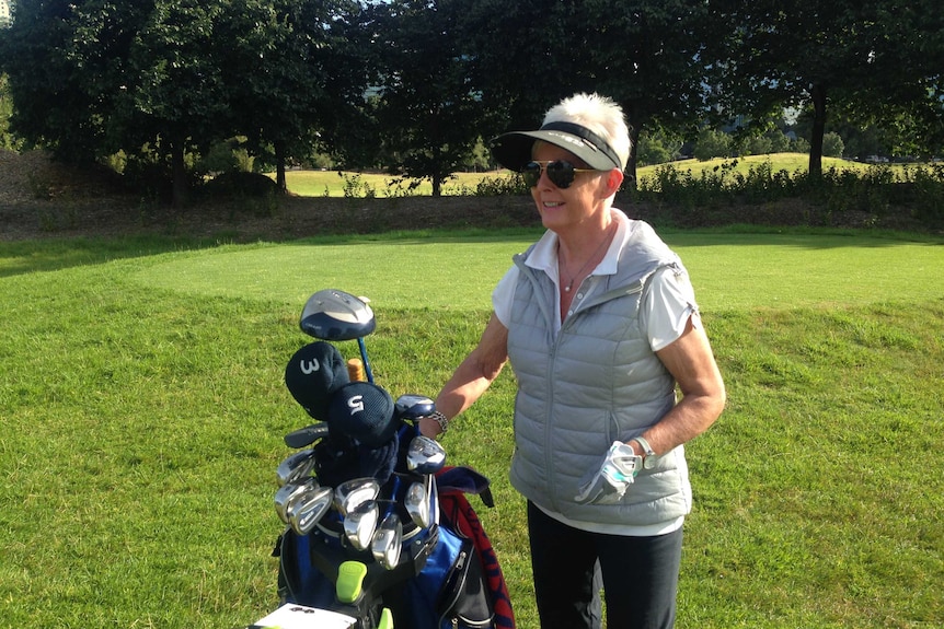 Golfer Julie Lansell with her golf clubs at the Albert Park Golf Course.