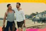 Two men in Bros are seen strolling along a beach happily, with their arms around each other. One is muscly, the other thin.