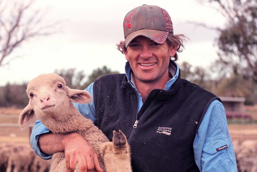 Sheep and grain producer Jason Stokes from Nanson in WA with one of his lambs near the yards at his farm Mount Erin.