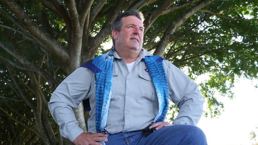 A photo of 50-year-old fisherman Wesley posing with the shirt he survived the ordeal in.