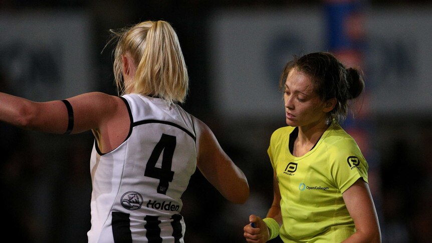 Collingwood's Sarah D'Arcy stands in defence while an umpire reports her.