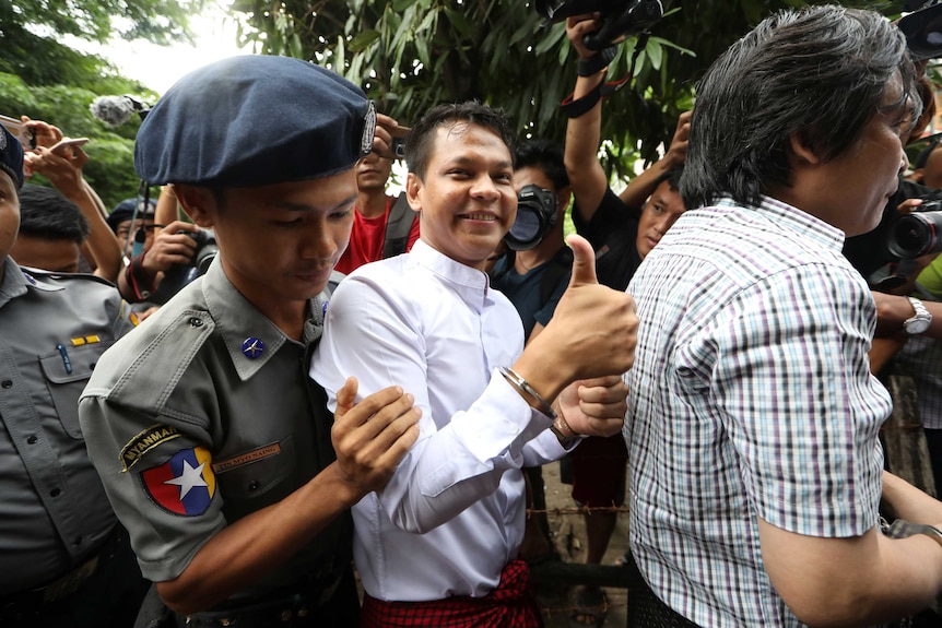 Eleven Media reporter Phyo Wai Win gives the thumbs up after being detained at Tamwe court in Yangon.