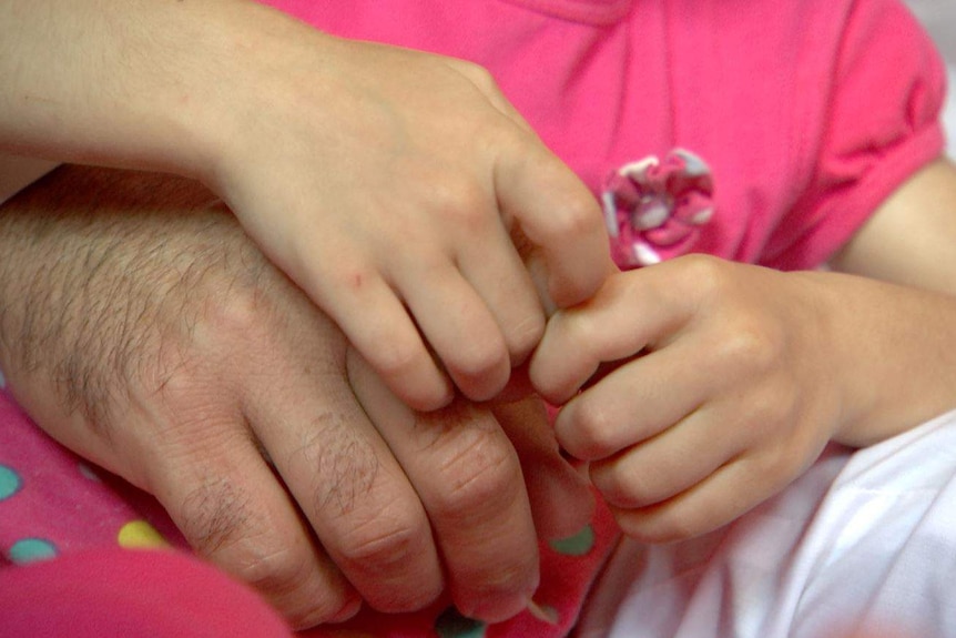 Abdullah and his niece hold hands